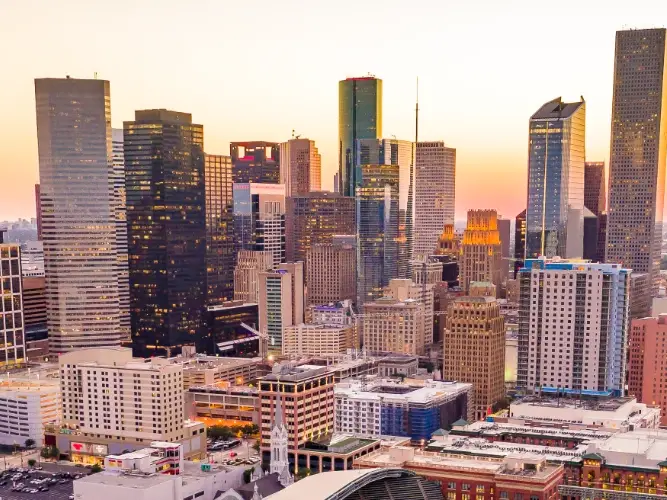 A city skyline with many skyscrapers at sunset