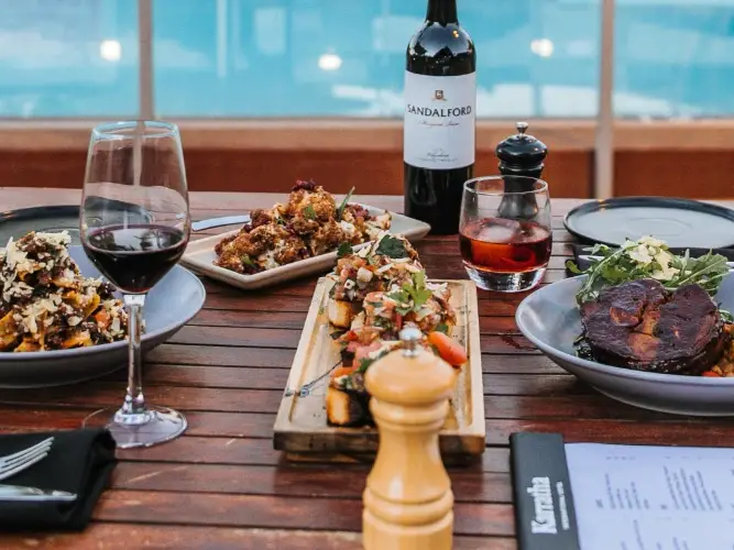 A table set with various dishes and glasses of wine.